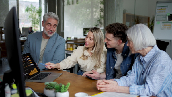 Businessman giving a presentation in a business meeting. Young colleagues and manager having casual discussion during meeting, workshop in office.