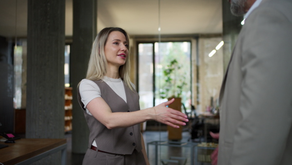 A male manager talking with his employee in modern office. Company director is happy, satisfied for workers quality work.