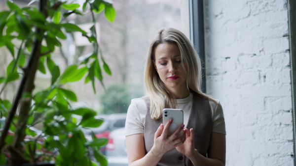 A video of female worker taking a break from work, scrolling her smartphone. Concept of the corporate work.