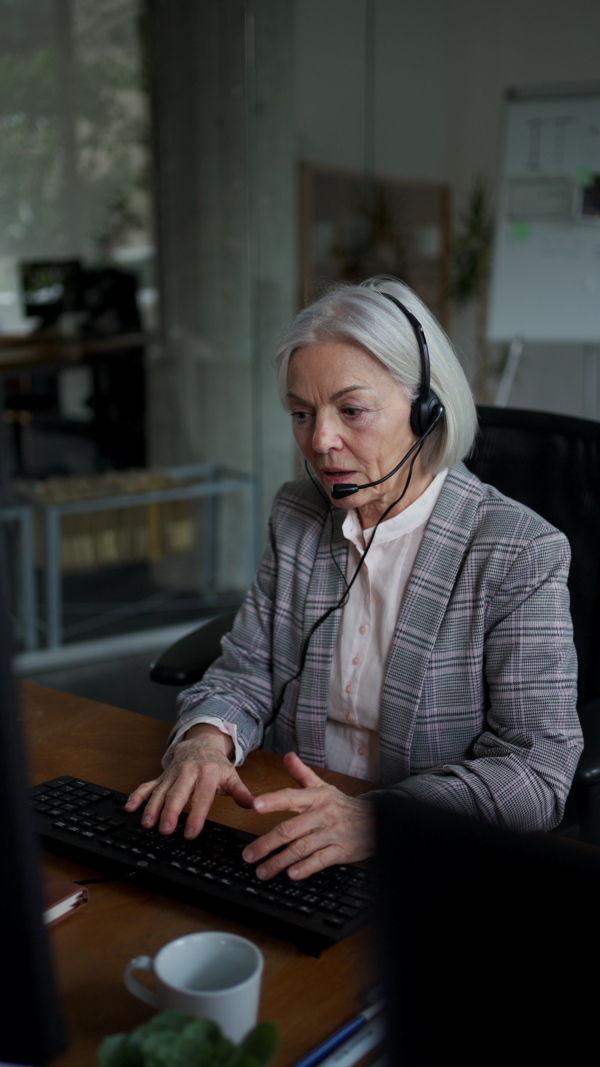 Female manager has migraine, headache. Woman with headset on head is overworked in her job, burnout syndrome for corporate worker. Woman feeling under pressure, health problems.