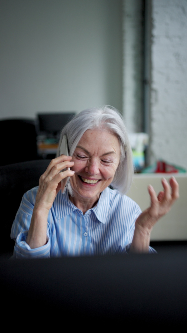 Successful business deal for older manager working in office. Beautiful mature woman making phone call.