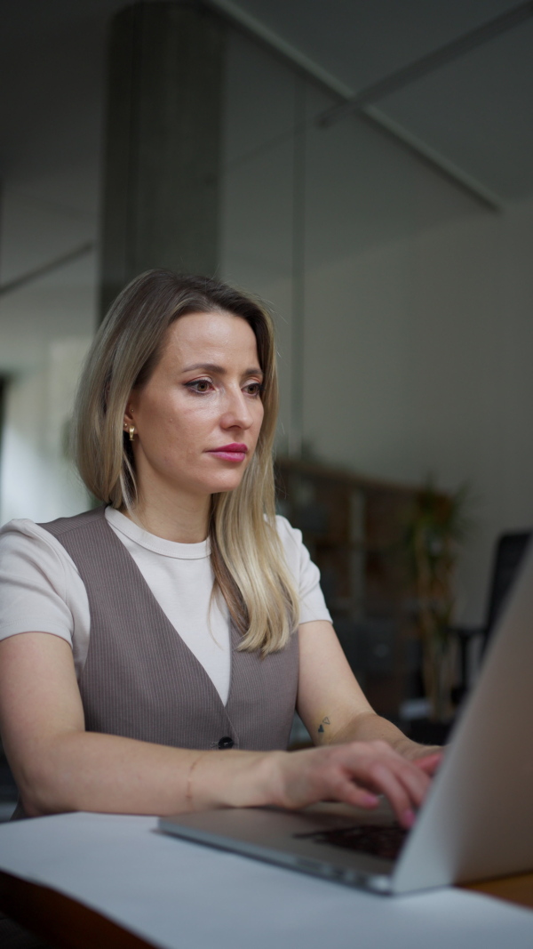 A video of female worker worikng on her laptop in the office. Concept of the corporate work.