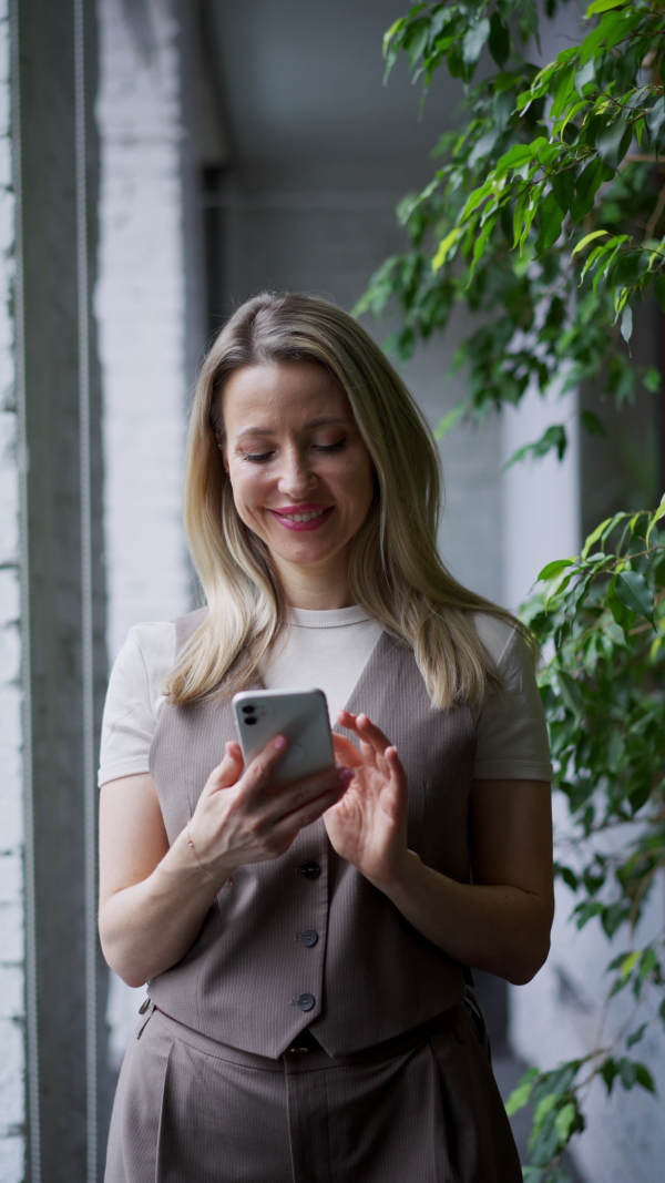 A video of female worker taking a break from work, scrolling her smartphone. Concept of the corporate work.