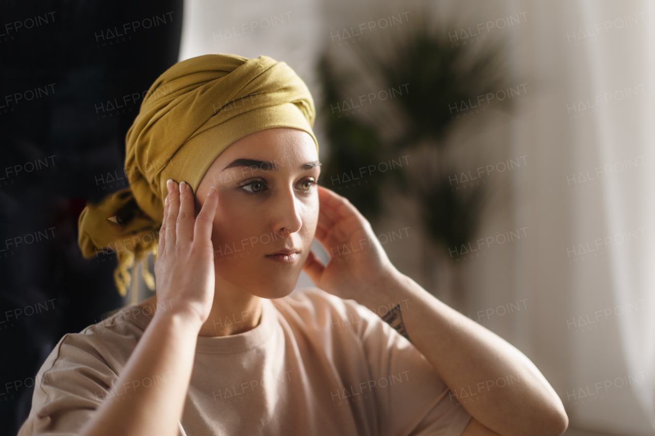 Portrait of young woman with cancer at her home.