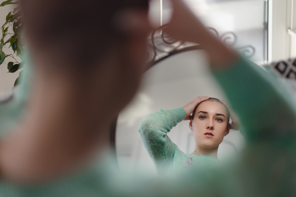 Beauty routine of a young woman with cancer, getting scarf.