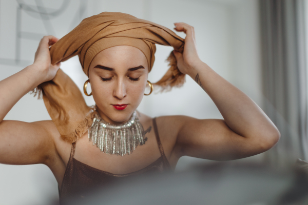 Beauty routine of a young woman with cancer, getting scarf.