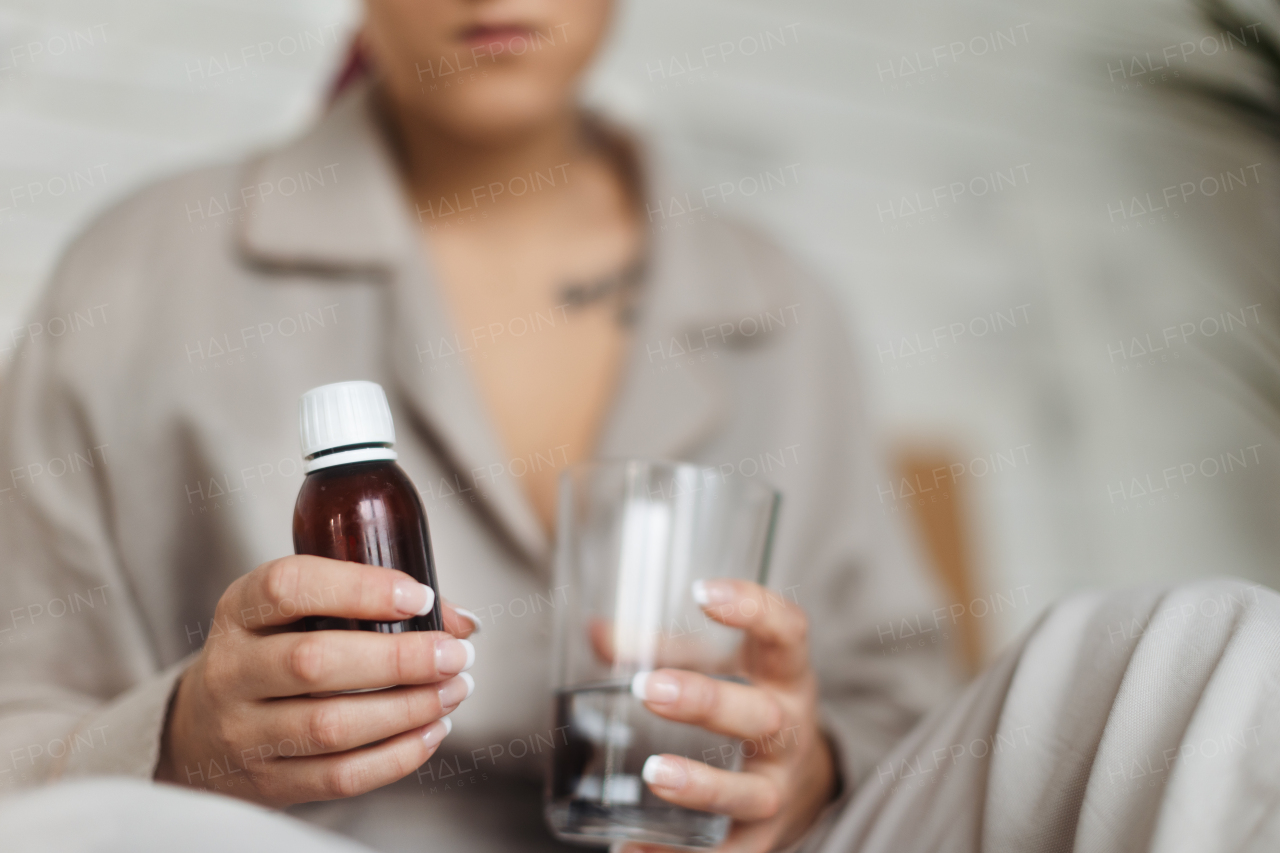 Close-up of woman with cancer taking the pills, cancer awareness concept.