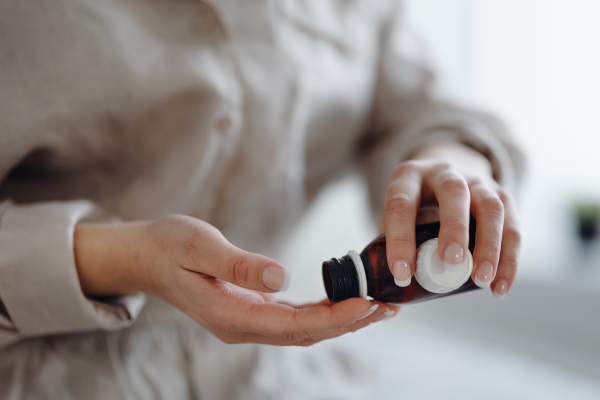 Close-up of woman with cancer taking the pills, cancer awareness concept.