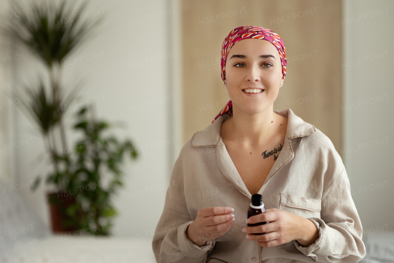 Young woman with cancer taking the pills, cancer awareness concept.