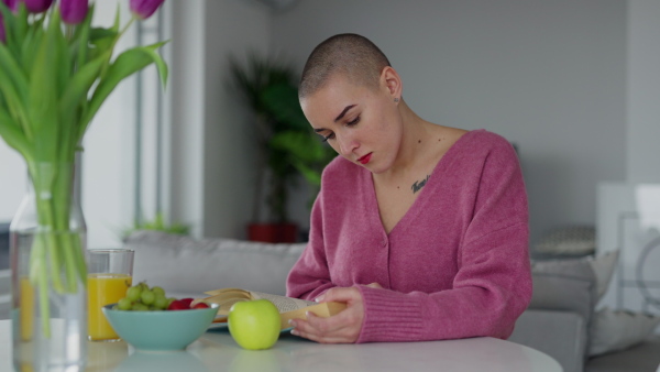 Young woman with cancer reading a book, cancer awareness concept.