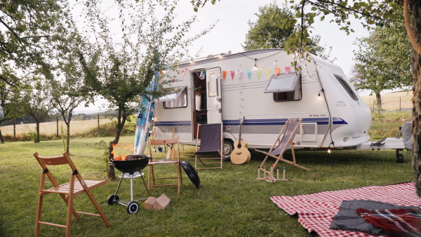 Traveling in a caravan, camping and exploring new places. Picnic diner in front of caravan.