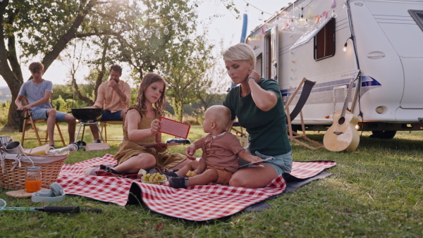 Mother playing outdoor games with daughter and small toddler son. Family traveling in a caravan, camping and exploring new places.