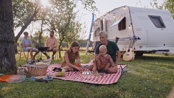 Mother playing outdoor games with daughter and small toddler son. Family traveling in a caravan, camping and exploring new places.