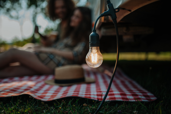 Couple sitting in front of caravan, close up of outdoor light.