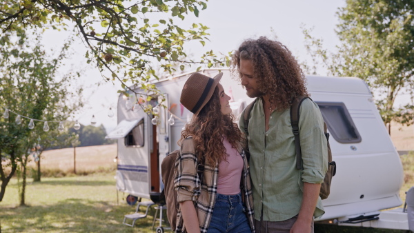 Young couple in love on a roadtrip with a caravan, camping and exploring new places.