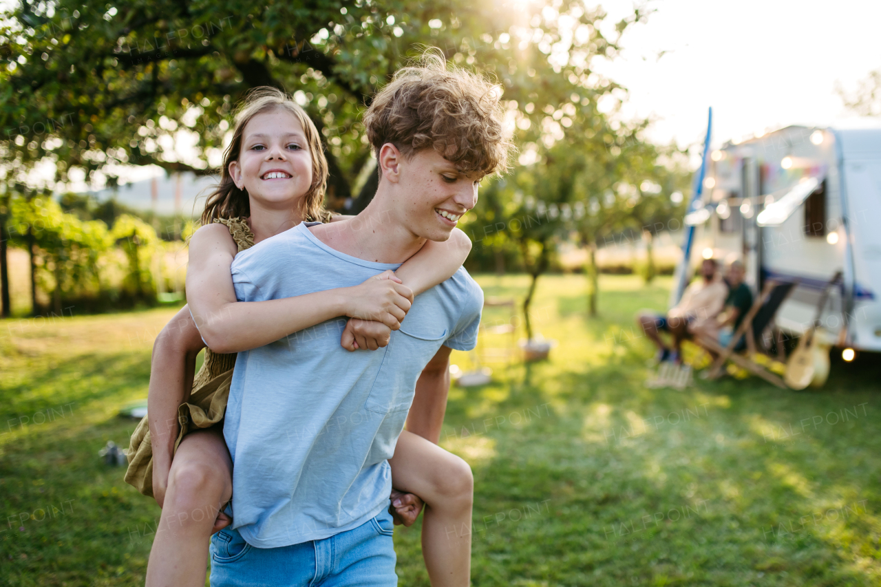 Two siblings are playing outdoor, having fun during warm summer evening.