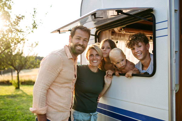 Portrait of family in caravan during their camping trip. Family roadtrip in caravan.