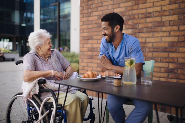 Caregiver having breakfast with his client at a cafe.