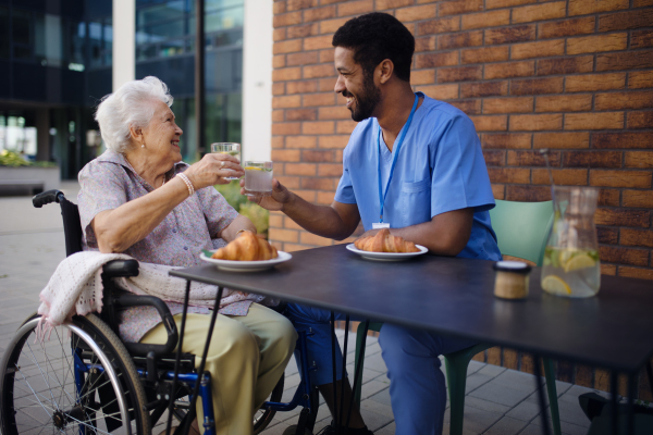 Caregiver having breakfast with his client at a cafe.