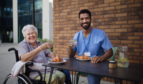 Caregiver having breakfast with his client at a cafe.