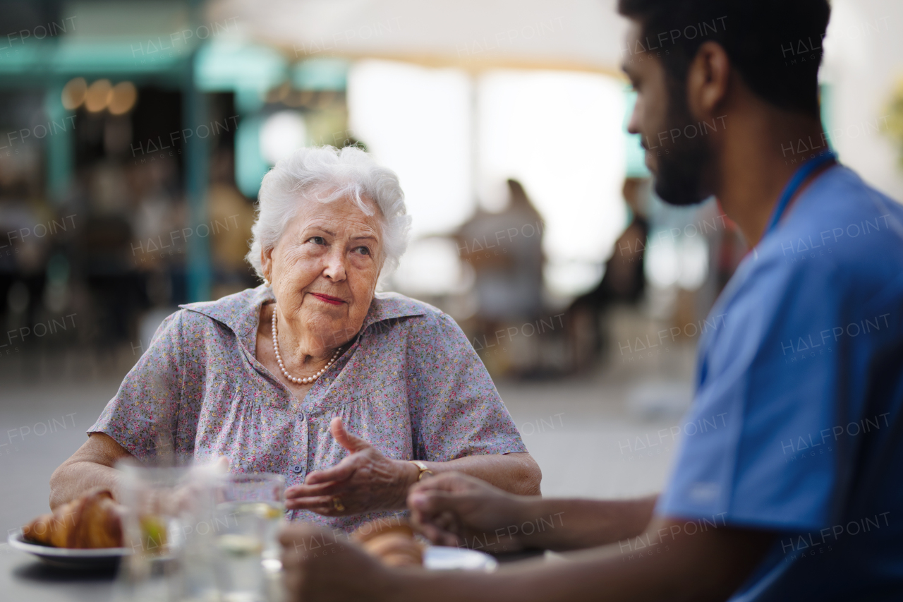 Caregiver having breakfast with his client at a cafe.