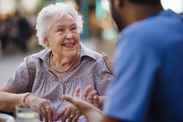 Caregiver talking with his client at a cafe, having nice time together.