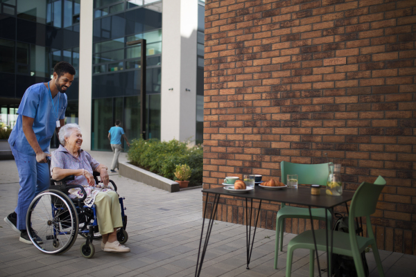 Caregiver having breakfast with his client at a cafe.