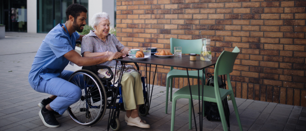 Caregiver having breakfast with his client at a cafe.