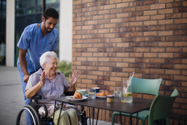 Caregiver having breakfast with his client at a cafe.