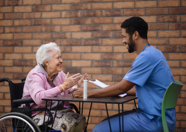 Caregiver explaining dosing pills to senior woman.