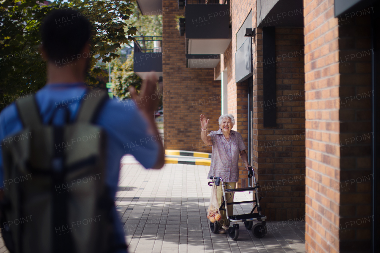 Caregiver saying goodbye his senior woman client at a nursing home.