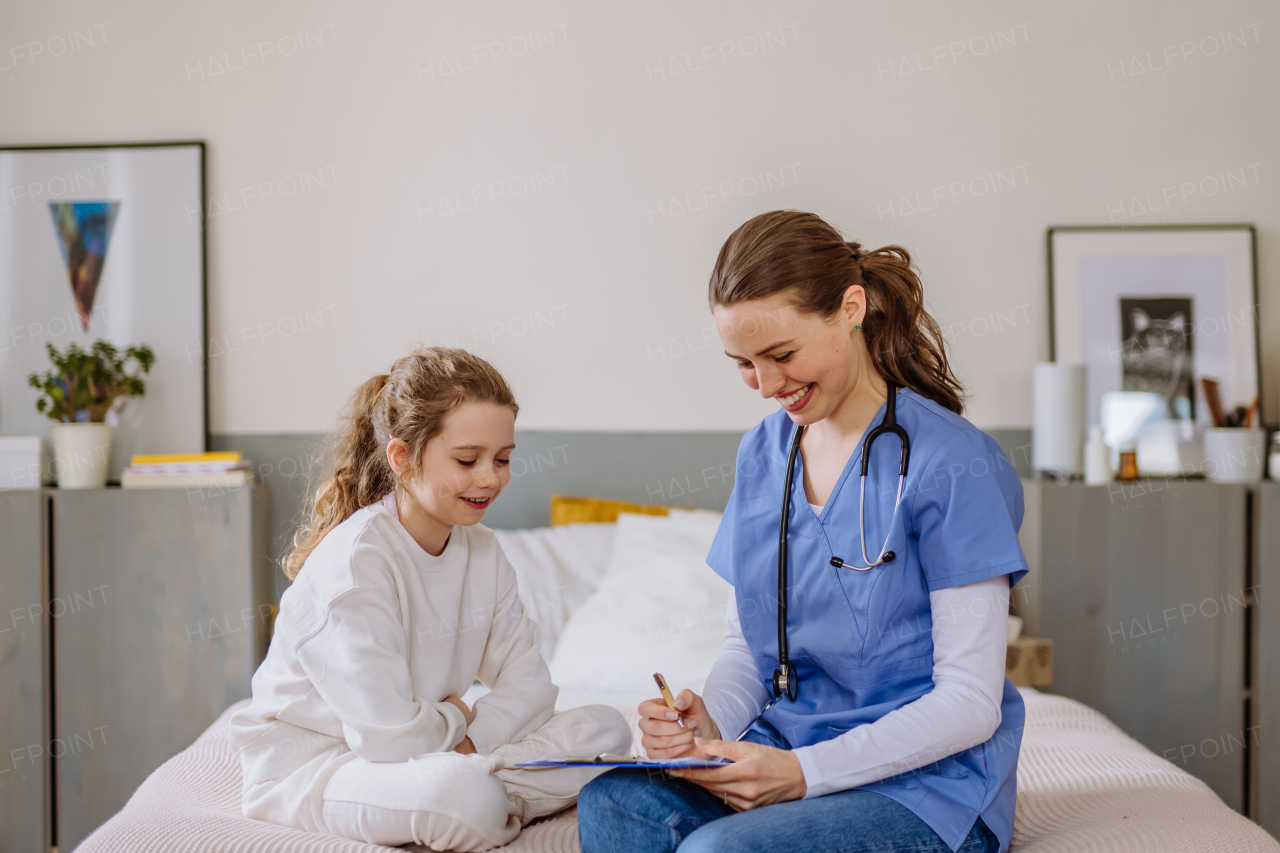 Young doctor taking care of little girl in a hospital room.