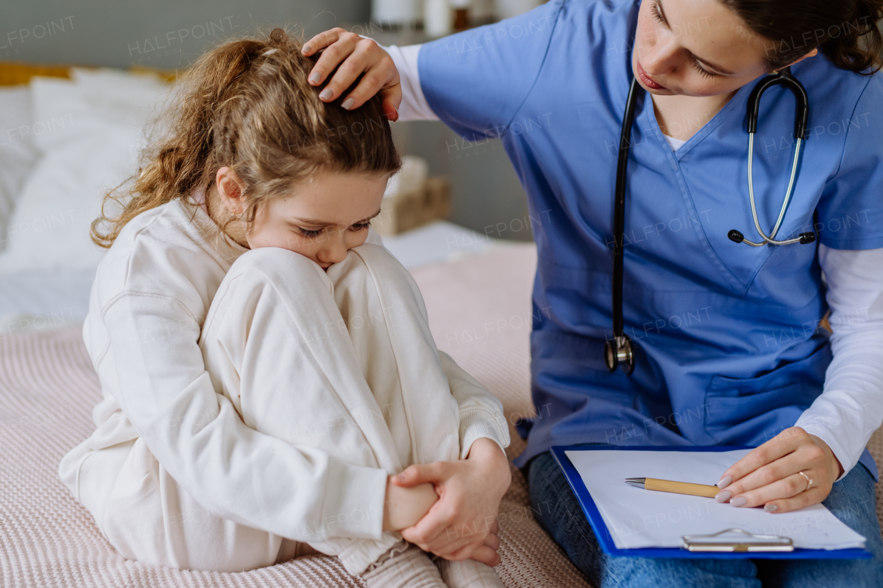 Young doctor taking care of little girl in a hospital room.