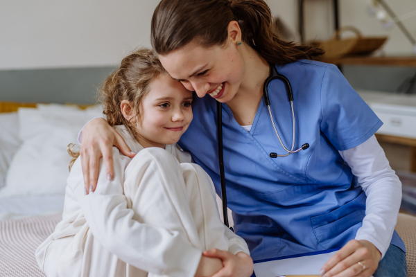 Young doctor consoling little girl in a hospital room.