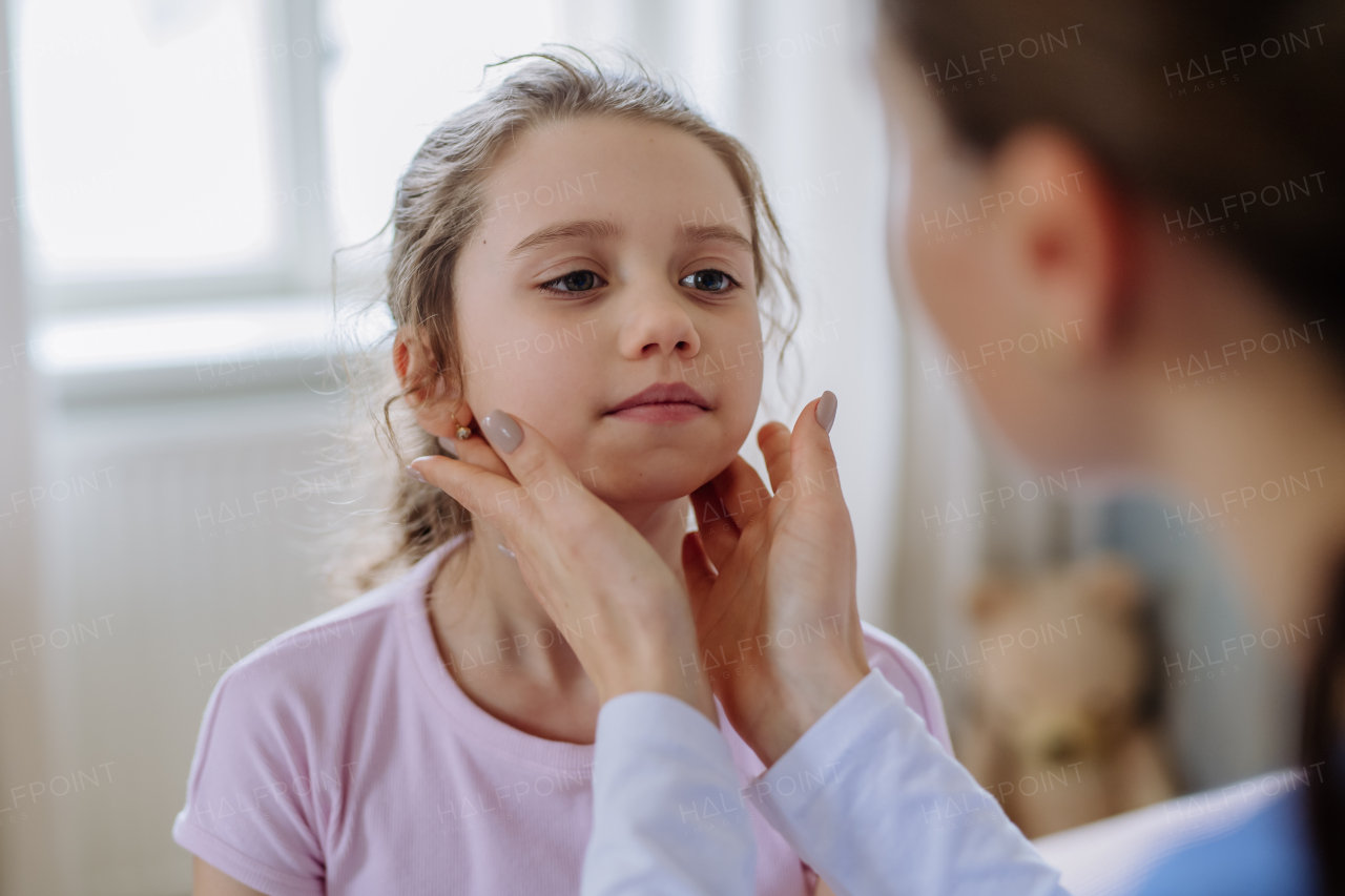 Young doctor taking care of little girl in a hospital room.