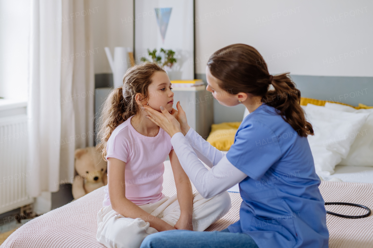 Young doctor taking care of little girl in a hospital room.