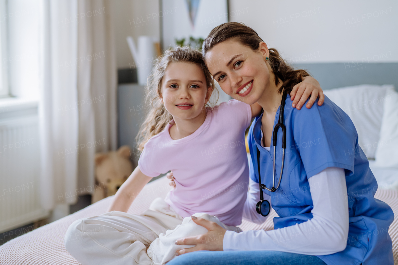 Young doctor taking care of little girl in a hospital room.