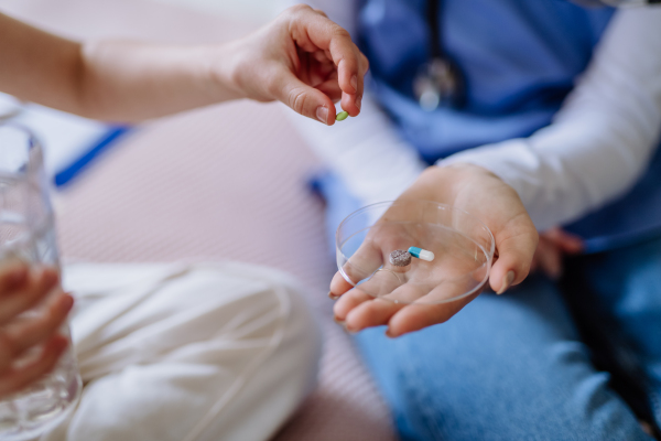 Close up of nurse giving pills to a patient.