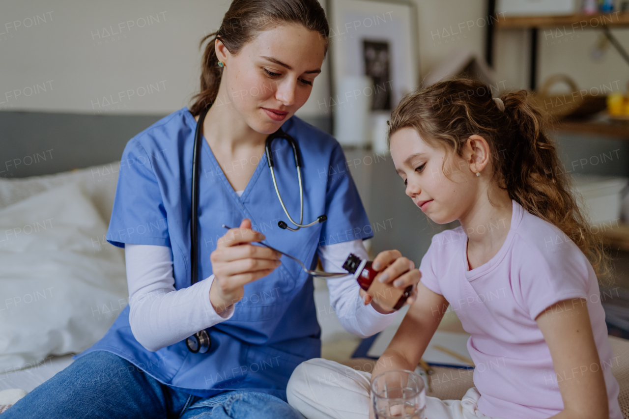 Young doctor taking care of little girl in a hospital room.