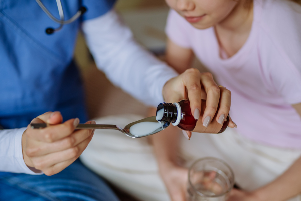 Close up of nurse giving medicine to a patient.