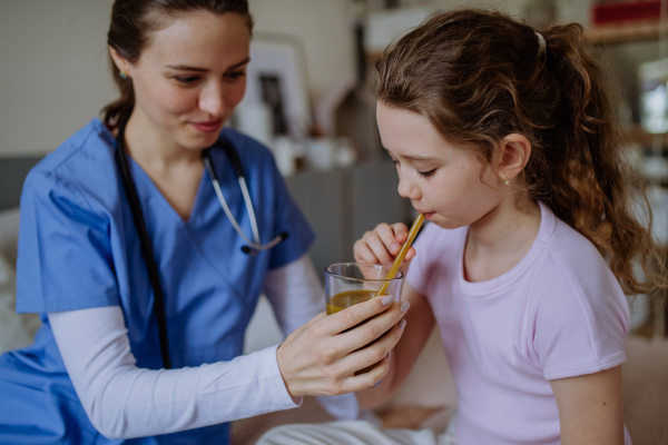 Young doctor taking care of little girl in a hospital room.