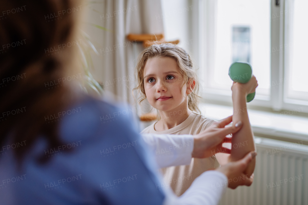 Little girl doing exercise with a physiotherapist.