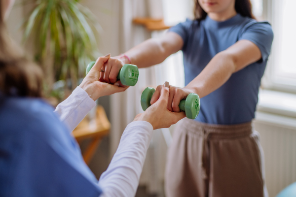 Teenage girl doing exercise with a physiotherapist.