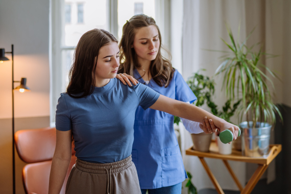 Teenage girl doing exercise with a physiotherapist.