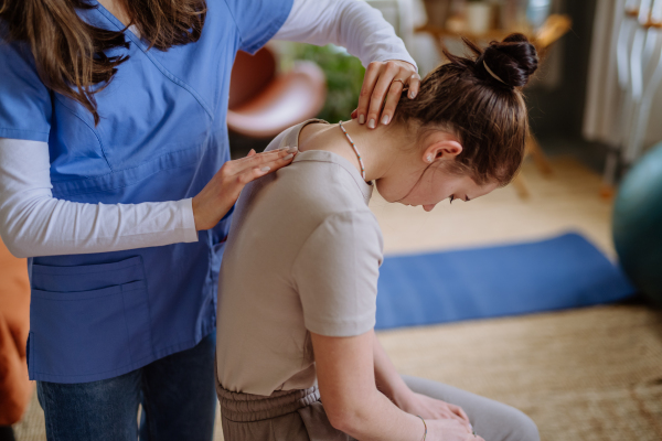 Teenage girl doing exercise with a physiotherapist.