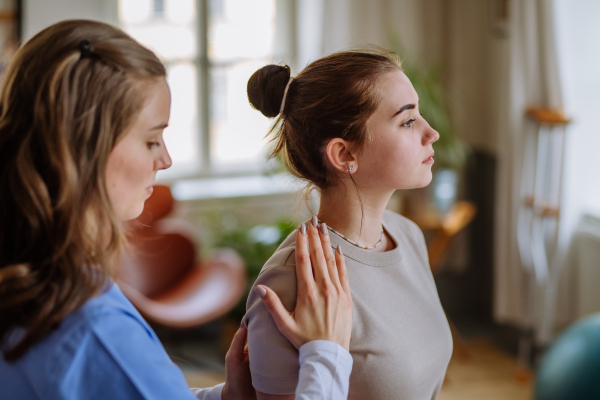 Teenage girl doing exercise with a physiotherapist.