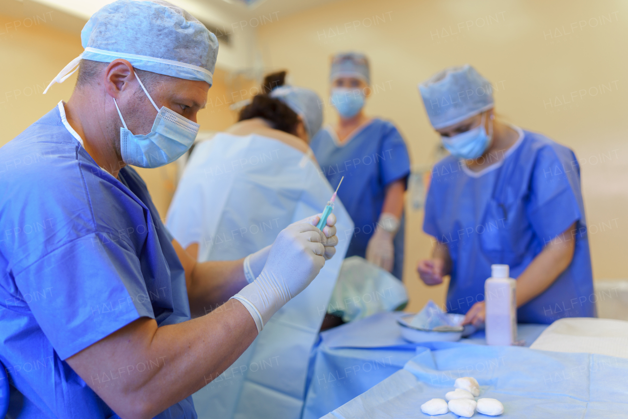 Spinal anesthesia before C-section. Anesthesiologist administering a dose of anesthetic near spinal cord, in the lower back.