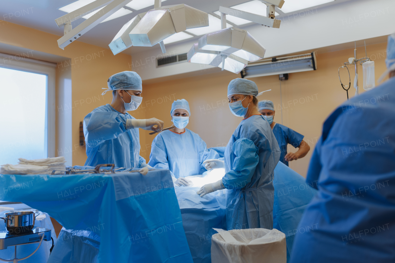 Healthcare team is preparing for surgery, opearation. Operating room with doctors, surgeons, anesthesiologist, scrub techs, surgical instrumentalist and nurses.