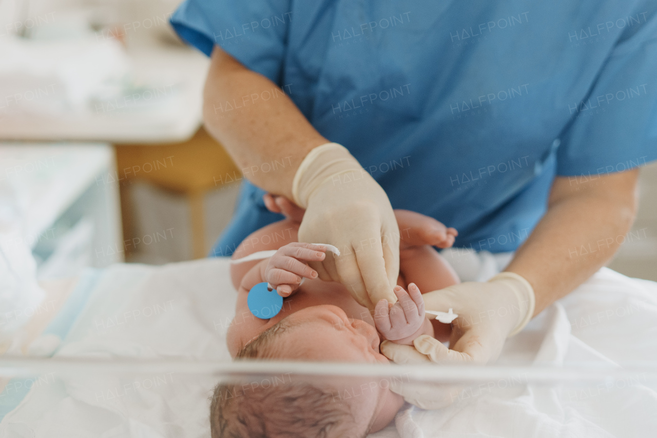 Neonatal nursers, doctor examining newborn baby, taking care of infant after birth. Neonatal care, newborn's health and well-being.