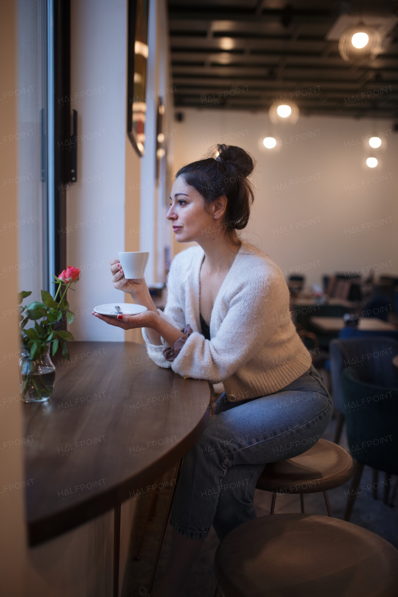 Young woman enjoying cup of coffee,sitting in cafe.